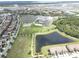 A scenic aerial view of a residential community with a central lake, modern buildings, and lush greenery at 10423 Belfry Cir, Orlando, FL 32832