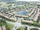 An aerial view of a community with a golf course, lake, and clubhouse at 10423 Belfry Cir, Orlando, FL 32832