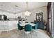 Dining room featuring a modern chandelier over a round dining table with six upholstered chairs and brick accent wall at 10423 Belfry Cir, Orlando, FL 32832