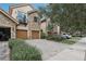 Charming townhome featuring a stone facade, private balcony, and a paver driveway leading to a two-car garage at 10423 Belfry Cir, Orlando, FL 32832