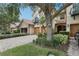 Charming townhome featuring a stone facade, private balcony, and a paver driveway leading to a two-car garage at 10423 Belfry Cir, Orlando, FL 32832