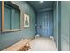 Stylish foyer with a serene blue color palette, featuring a bench, decorative mirror, and light wood flooring at 10423 Belfry Cir, Orlando, FL 32832