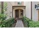 Inviting front entrance with landscaped walkway leading to a warm-toned home featuring the house number and a covered entryway at 10423 Belfry Cir, Orlando, FL 32832