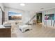 Bright living room featuring a built in entertainment unit, light wood flooring, modern furniture, and an artistic painting at 10423 Belfry Cir, Orlando, FL 32832