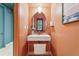 Stylish powder room with a unique mirror, modern sink and fixtures, and bold wall color at 10423 Belfry Cir, Orlando, FL 32832