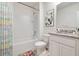 Bright bathroom with a shower-tub combo, colorful shower curtain, and granite vanity at 1192 Alstonia Ln, Mount Dora, FL 32757
