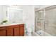 Bathroom with modern shower with sliding glass doors, and vanity with brown cabinets at 1512 Mumbai Way, Kissimmee, FL 34747