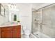 Bathroom with modern shower with sliding glass doors, and vanity with brown cabinets at 1512 Mumbai Way, Kissimmee, FL 34747