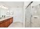 Bathroom with modern shower with sliding glass doors, and double vanity with brown cabinets at 1512 Mumbai Way, Kissimmee, FL 34747