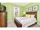 Cozy bedroom featuring a wooden bed frame, soft green walls, and ample natural light at 1512 Mumbai Way, Kissimmee, FL 34747