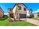 Charming two-story home with a well-kept lawn, palm trees, and a two-car garage at 1512 Mumbai Way, Kissimmee, FL 34747