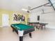 Spacious game room with pool table, ping pong, and vibrant superhero decor, ideal for entertainment at 1512 Mumbai Way, Kissimmee, FL 34747