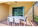 Covered patio featuring a dining table, chairs, and a view of the backyard and pool at 1512 Mumbai Way, Kissimmee, FL 34747