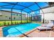 Inviting pool with a screened enclosure, complemented by comfortable lounge chairs and manicured landscaping at 1512 Mumbai Way, Kissimmee, FL 34747