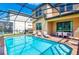 Sparkling pool with lounge chairs and outdoor dining, all enclosed in a screened-in lanai at 1512 Mumbai Way, Kissimmee, FL 34747