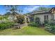 This backyard features a stone table, benches, well-manicured lawn, and a variety of shrubs at 1606 Orangewood Ave, Orlando, FL 32806