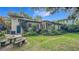 This charming backyard features a stone table, benches, and lush greenery, perfect for outdoor relaxation at 1606 Orangewood Ave, Orlando, FL 32806