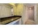 Bathroom with a marble countertop, patterned wallpaper, and a shower with a glass door at 1606 Orangewood Ave, Orlando, FL 32806