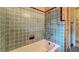 Vintage tiled bathroom with a tub and unique design elements at 1606 Orangewood Ave, Orlando, FL 32806