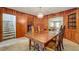 Warm, wood-paneled dining room with a spacious table, seating for six, and carpeted floors at 1606 Orangewood Ave, Orlando, FL 32806
