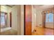 Hallway featuring hardwood floors, window, and multiple doorways at 1606 Orangewood Ave, Orlando, FL 32806