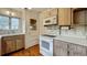 Bright kitchen with wood cabinets, white appliances, and hardwood floors at 1606 Orangewood Ave, Orlando, FL 32806