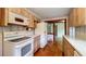 Traditional kitchen with wood cabinets, white appliances, and hardwood floors at 1606 Orangewood Ave, Orlando, FL 32806