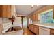 Well-lit kitchen with wood cabinets, vintage wallpaper, and white appliances at 1606 Orangewood Ave, Orlando, FL 32806