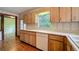 Charming kitchen with wood cabinets, vintage wallpaper, hardwood floors and white dishwasher at 1606 Orangewood Ave, Orlando, FL 32806