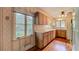 Light and bright kitchen with wood cabinets, hardwood floors, and a large window overlooking the yard at 1606 Orangewood Ave, Orlando, FL 32806