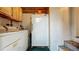 Laundry area with washer, dryer and refrigerator in a narrow utility space at 1606 Orangewood Ave, Orlando, FL 32806