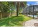 Sprawling green backyard, framed by a screened-in pool and bricked walkway at 1689 Wingspan Way, Winter Springs, FL 32708