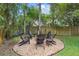 Backyard stone fire pit with surrounding Adirondack chairs at 1689 Wingspan Way, Winter Springs, FL 32708
