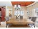 Bright dining area boasts a rustic table and chairs with a view of the pool outside at 1689 Wingspan Way, Winter Springs, FL 32708