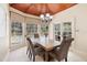 Charming dining room with wood table, chandelier, and large windows overlooking the pool at 1689 Wingspan Way, Winter Springs, FL 32708