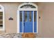 Close up of the front door with a transom window and 'how doodle you do' welcome mat at 1689 Wingspan Way, Winter Springs, FL 32708