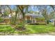 Charming home featuring a blue front door, lush landscaping and mature trees at 1689 Wingspan Way, Winter Springs, FL 32708
