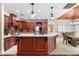 Open kitchen design featuring custom wood cabinetry, granite countertops, and stainless steel appliances at 1689 Wingspan Way, Winter Springs, FL 32708
