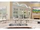 Kitchen features granite countertops, stainless steel sink, and view of the backyard through large windows at 1689 Wingspan Way, Winter Springs, FL 32708
