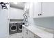 Modern laundry room with white cabinets, marble countertops, and stainless steel appliances at 1689 Wingspan Way, Winter Springs, FL 32708