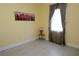 Sunny bedroom with laminate flooring, yellow walls, and a window with neutral curtains at 1764 Carillon Park Dr, Oviedo, FL 32765