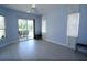 Bedroom with blue walls, light wood floors, and a sliding glass door leading to the backyard at 1764 Carillon Park Dr, Oviedo, FL 32765