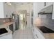 Elegant kitchen with white cabinets, granite counters, and stainless steel appliances overlooking the dining room at 1764 Carillon Park Dr, Oviedo, FL 32765