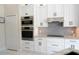 Modern kitchen boasting white cabinets, granite countertops, and stainless steel appliances at 1764 Carillon Park Dr, Oviedo, FL 32765