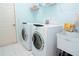 Well-lit laundry room features modern washer and dryer units, and a utility sink for added convenience at 1764 Carillon Park Dr, Oviedo, FL 32765