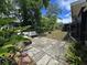 Backyard patio featuring stone pavers, a bench, tropical plants, and partial fencing at 1902 Sarazen Dr, Orlando, FL 32808