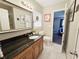 Bathroom featuring vanity with black granite countertop, large framed mirror, and updated fixtures at 1902 Sarazen Dr, Orlando, FL 32808