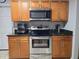 Well-equipped kitchen showcasing stainless steel appliances and wood cabinets for modern convenience at 1902 Sarazen Dr, Orlando, FL 32808