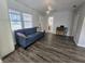 Cozy living room with plush blue sofa, wood flooring, and natural light from the large window at 1902 Sarazen Dr, Orlando, FL 32808