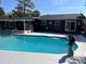 Sparkling pool with well-maintained patio, mermaid statue, and screened-in lanai, creating a serene outdoor oasis at 1902 Sarazen Dr, Orlando, FL 32808